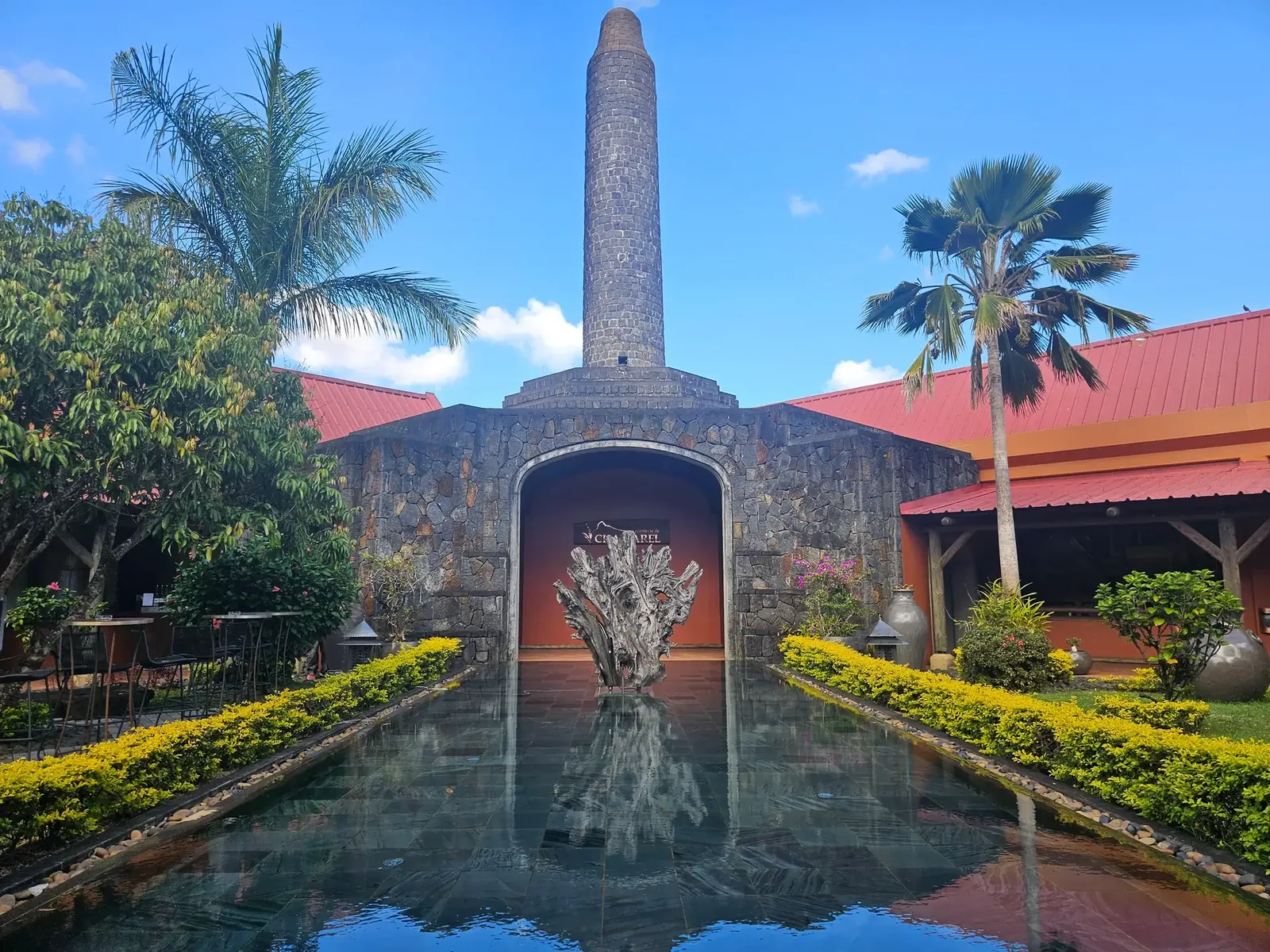 Stone entrance, gardens and reflecting pool at Rhumerie de Chamarel in Mauritius.
